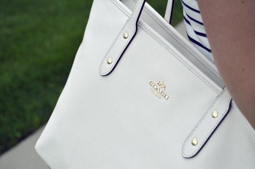 Detailfoto van een designertas waarbij stiksels en hardware van dichtbij worden geïnspecteerd op echtheid