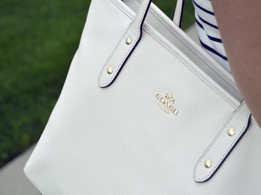 Detailfoto van een designertas waarbij stiksels en hardware van dichtbij worden geïnspecteerd op echtheid