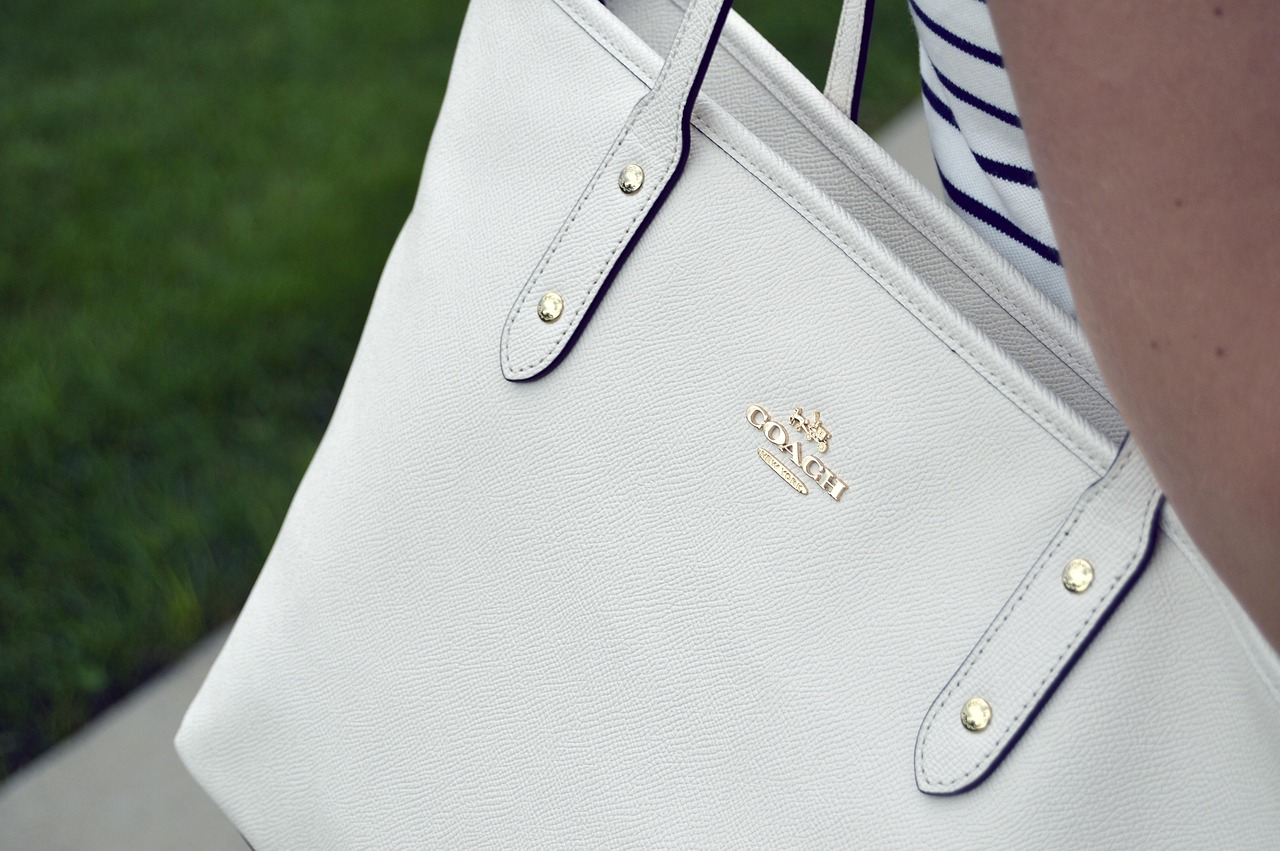 Detailfoto van een designertas waarbij stiksels en hardware van dichtbij worden geïnspecteerd op echtheid