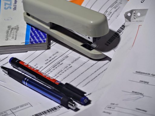 Een Engelse factuur liggend op een bureau naast een laptop en aantekeningen