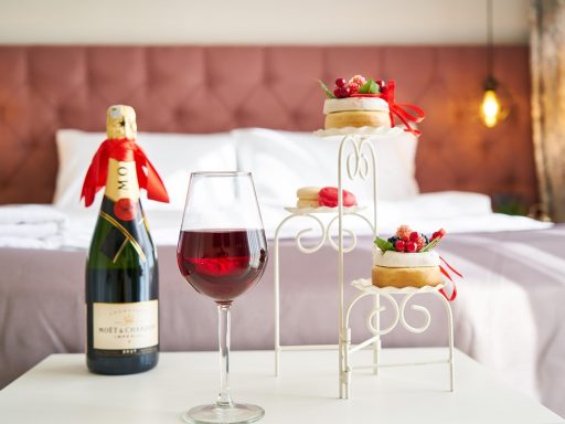 Gezonde snacks en fruit uitgestald op een hotelkamertafel naast een kleine koelkast