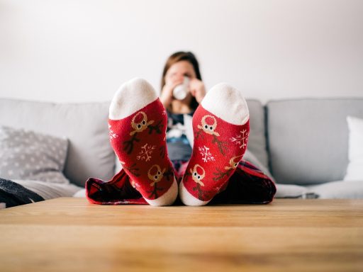 Persoon die reflectievragen opschrijft in een notitieboek aan een houten tafel