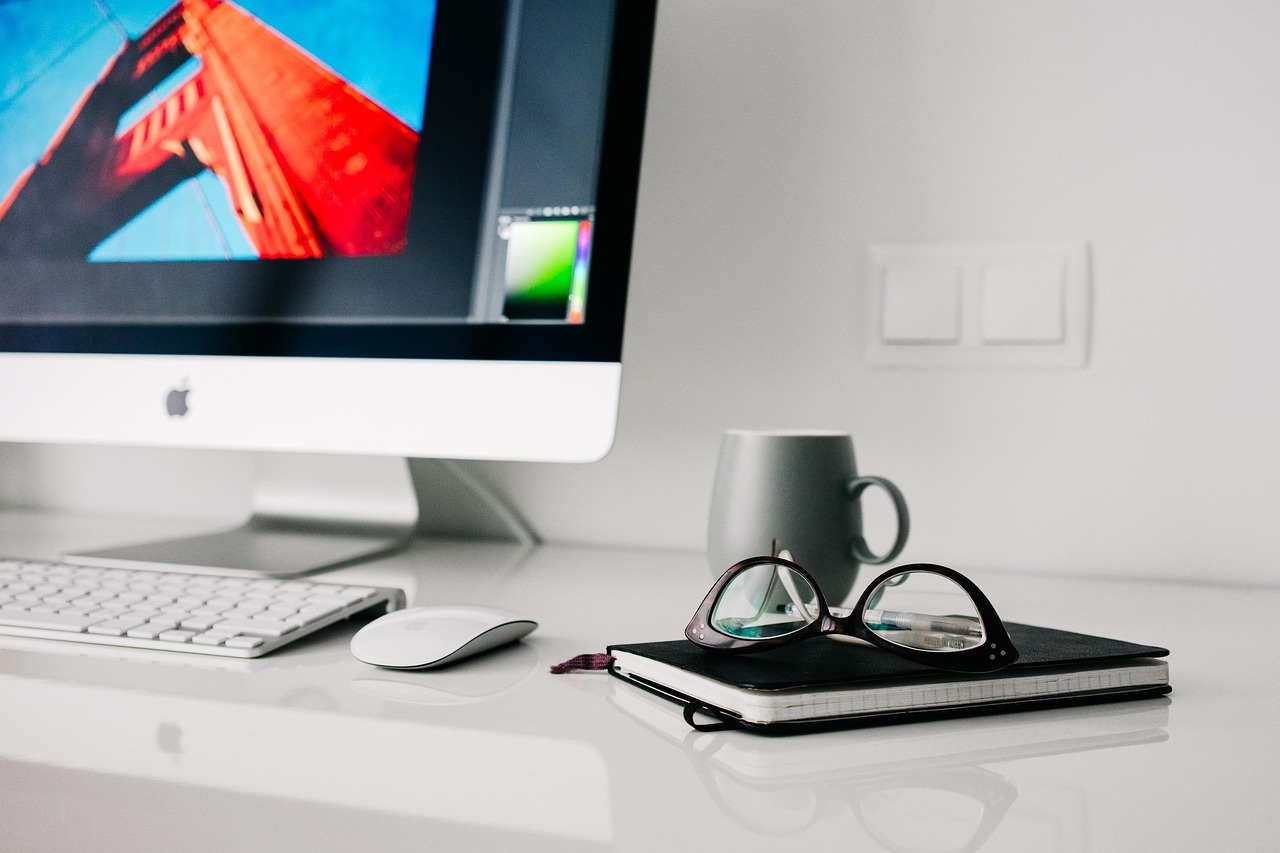 Nette thuiswerkplek met monitor, lamp en geordende kabels op een houten bureau