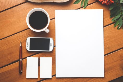 Meerdere tweedehands smartphones op een houten tafel klaar voor inspectie