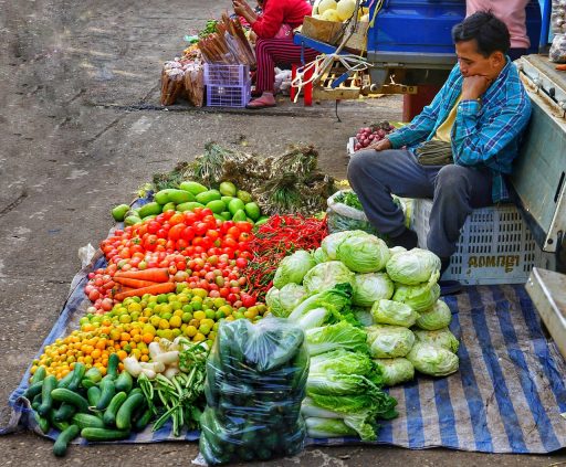 Marktkraam vol met verse tomaten, courgettes, bramen en pruimen in augustus