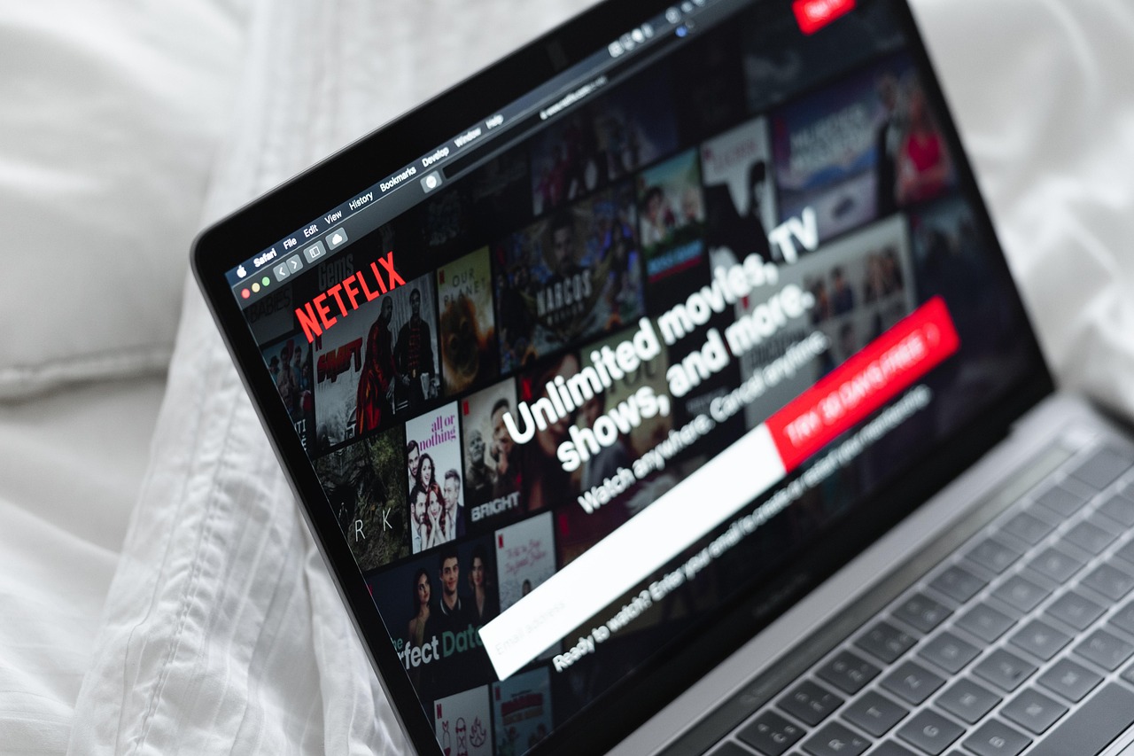 Persoon die Netflix bekijkt op een laptop in een donkere kamer