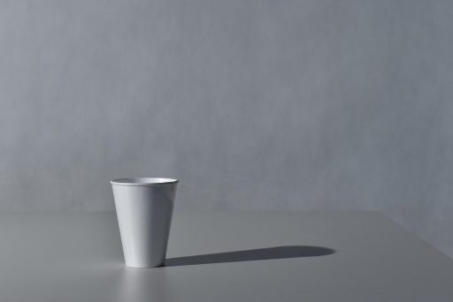 Een minimalistische outfit in neutrale tinten zoals ecru en kameel, gelegd op een licht oppervlak