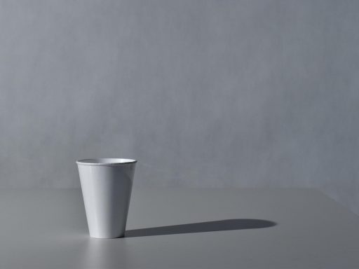 Een minimalistische outfit in neutrale tinten zoals ecru en kameel, gelegd op een licht oppervlak